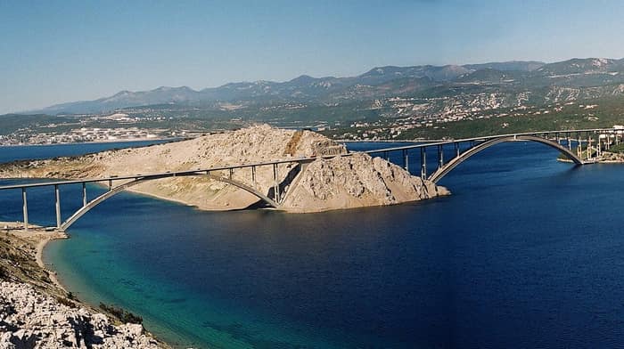 The larger arch of the Krk Bridge over the Tihi kanal channel between the mainland and the islet of Sveti Marko